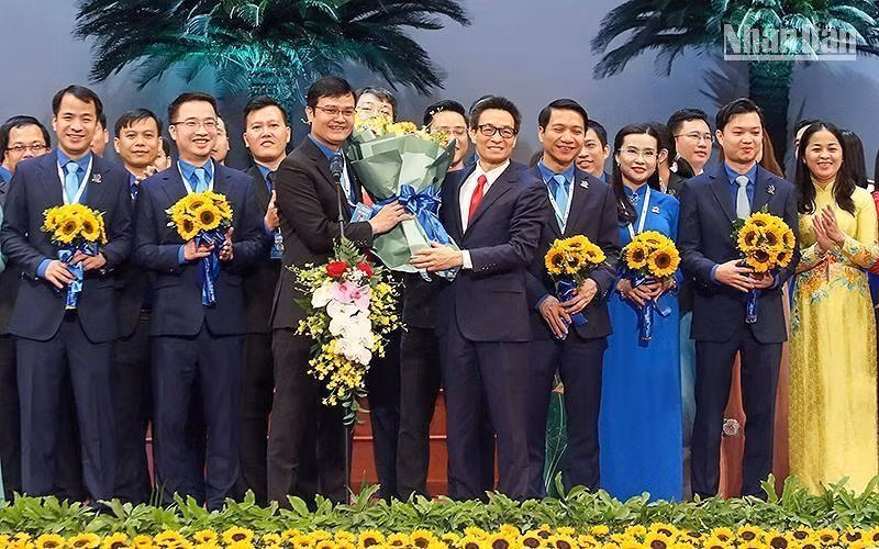 Вице-премьер Ву Дык Дам вручает цветы товарищу Буй Куанг Хюи и членам ЦК ВКСМ им Хо Ши Мина XII созыва.