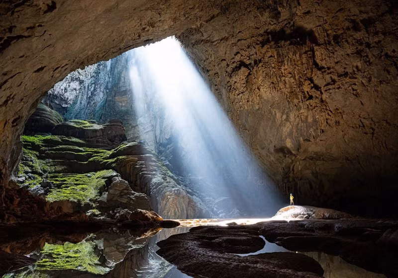 На фотографии, опубликованной в журнале National Geographic в январе 2022 года, изображен турист в солнечных лучах, стоящий в пещере Шондоонг, самой большой пещере в мире. На фотографии, опубликованной в журнале National Geographic в январе 2022 года, изображен турист в солнечных лучах, стоящий в пещере Шондоонг, самой большой пещере в мире.