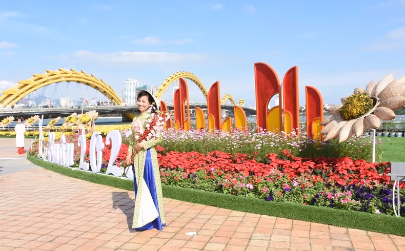 Вьетнамская посетительница фотографируется на цветочной улице.