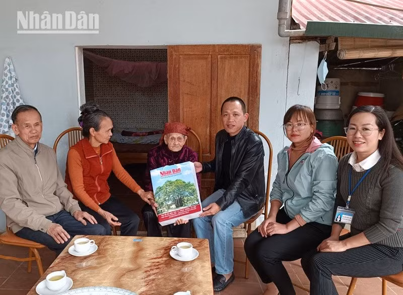 Представители газеты «Нянзан» поздравляют вьетнамскую мать-героиню c наступающим Тэтом. 