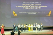 Лыу Тхи Нам Ха в желтом традиционном вьетнамском платье «аозай» в центре.