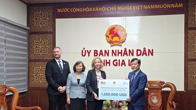 Генеральный консул США в г. Хошимине Мелисса Энн Браун символически вручает пакет помощи заместителю директора Департамента Нгуен Ван Тьену. 