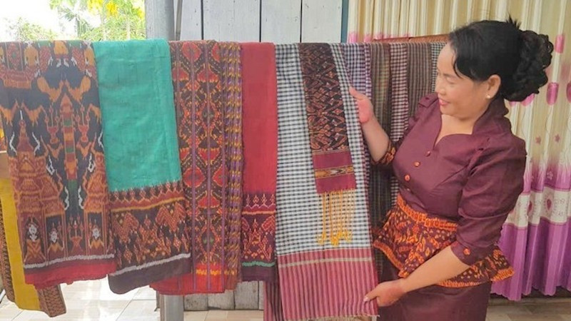 Госпожа Неанг Чань Ти, руководитель кооператива по ткачеству парчи народности Кхмер Ванзяо (община Анкы, провинция Анзянг), представляет уникальные изделия ремесленной деревни. Фото: dantocmiennui.baotintuc.vn