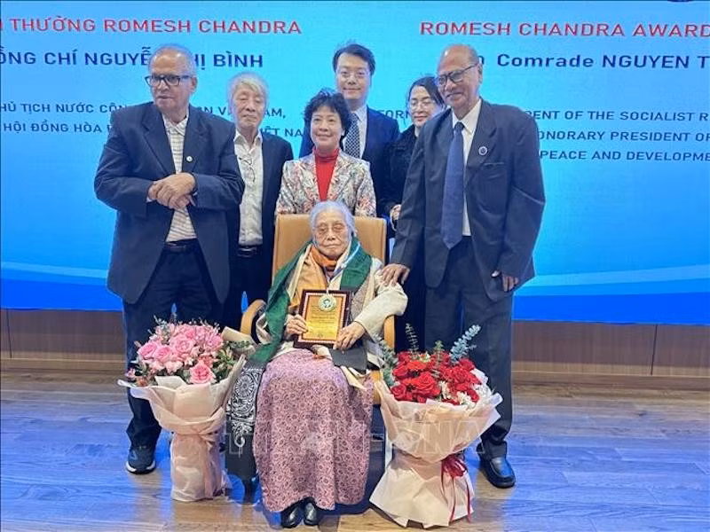 Представители AIPSO вручает премию Ромеша Чандры г-же Нгуен Тхи Бинь. Фото: ВИА