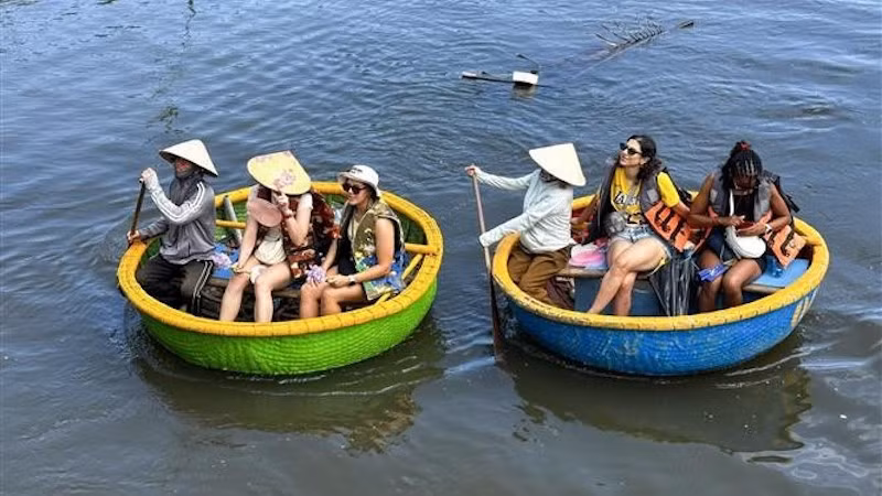 Иностранные туристы пробуют катание на лодке-корзине в кокосовом лесу Камтхань. Фото: ВИА