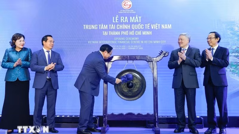 Премьер-министр Фам Минь Тьинь бьёт в гонг, открывая МФЦ в Хошимине. Фото: ВИА