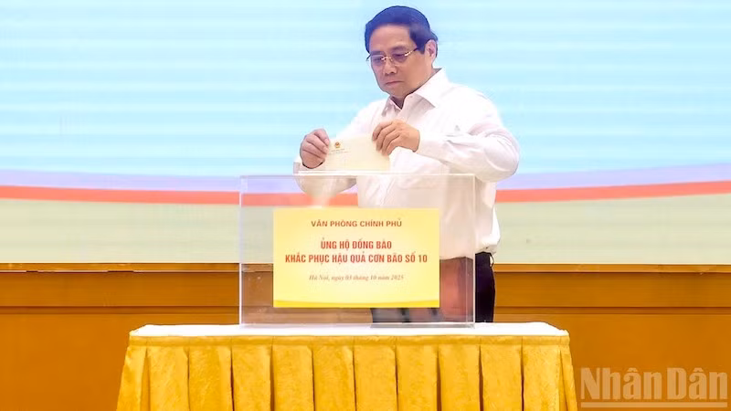 Премьер-министр Фам Минь Тьинь принимает участие в сборе пожертвований в поддержку соотечественников, пострадавших от тайфуна №10. Фото: Чан Хай