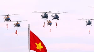 Выступление звена вертолетов Ми-171, Ми-17, Ми-8 с флагами Партии и Государства над районом площади Бадинь. Фото: ВИА