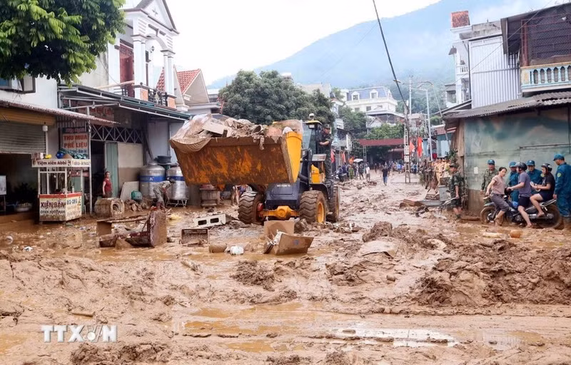 Экскаваторы были мобилизованы для выравнивания и сбора грязи, веток деревьев и мусора, смытых во время недавнего наводнения в общине Сонгма, провинция Шонла. (Фото: ВИА)