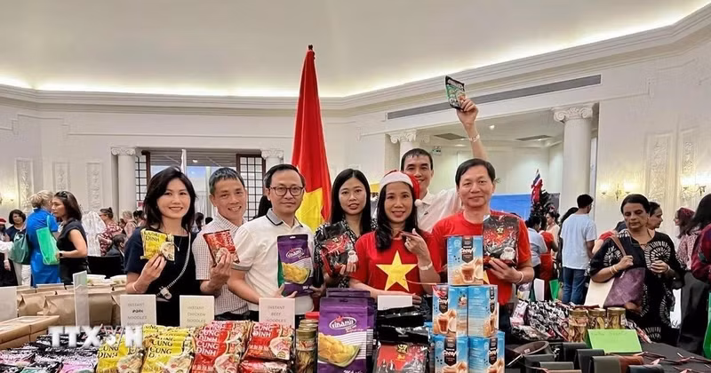 Посол Вьетнама в Шри-Ланке Чинь Тхи Там, сотрудники и супруги сотрудников Посольства Вьетнама в Шри-Ланке фотографирутся у вьетнамского стенда. (Фото: ВИА)