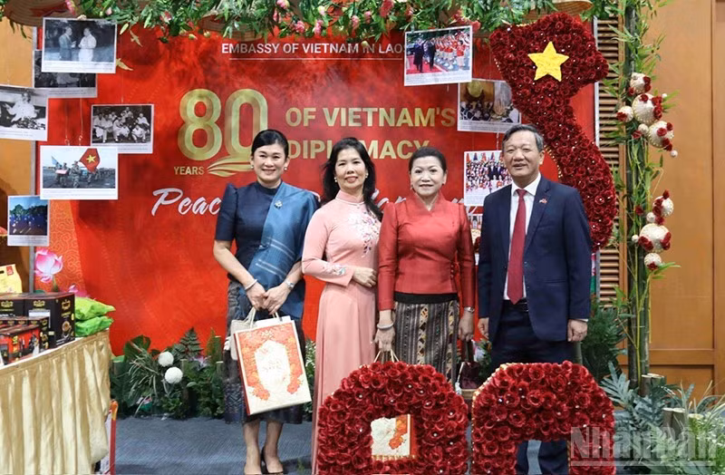 Посол Вьетнама в Лаоса Нгуен Минь Там вместе с супругой и международными друзьями у вьетнамского стенда. (Фото: Зюи Тоан)
