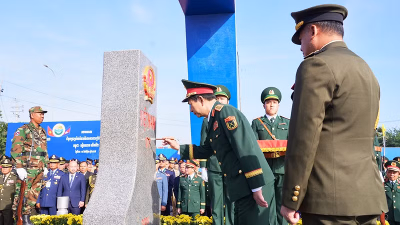 Генерал армии Тиа Сеиа, заместитель премьер-министра, министр национальной обороны Королевства Камбоджа, наблюдает, как генерал армии Фан Ван Жанг, министр национальной обороны Вьетнама, наносит краску на пограничный столб №171 в международном пункте пропуска Мокбай (провинция Тэйнинь). (Фото: ВИА)