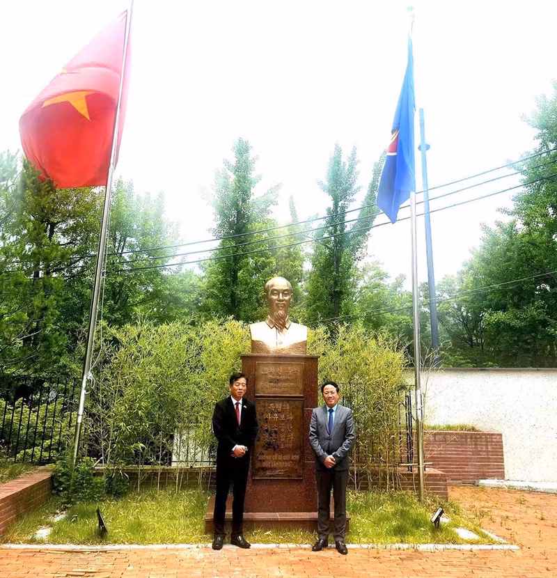 Посол Ву Хо и Председатель Фам Ань Туан фотографируются на память у памятника Президенту Хо Ши Мину на территории Посольства.
