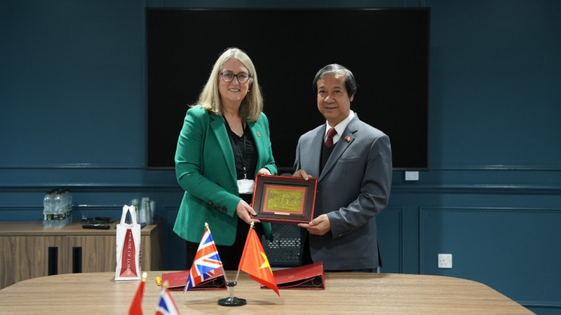 Министр образования и подготовки кадров Нгуен Ким Шон и баронесса Джеки Смит обмениваются памятными подарками. (Фото: ВИА)