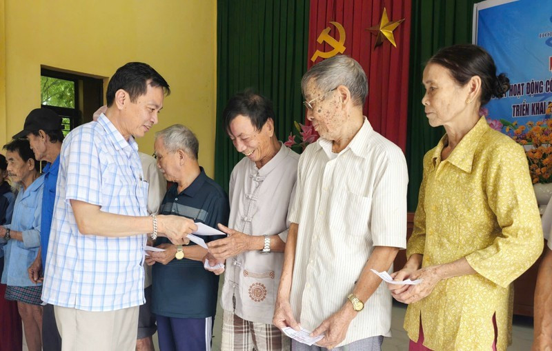 Представитель газеты «Нянзан» в провинции Куангчи передает денежную помощь жителям деревни Хойки в общине Намхайланг.