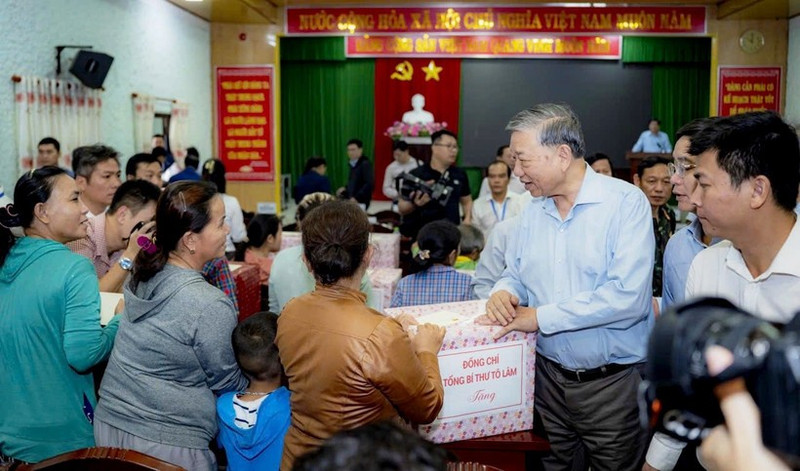 Генеральный секретарь ЦК КПВ То Лам вручает жителям подарки. (Фото: Тху Хюэ)