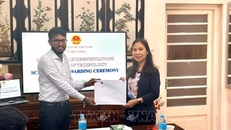 Посол Чинь Тхи Там вручает решение о предоставлении стипендии студенту. (Фото: предоставлено Посольством)