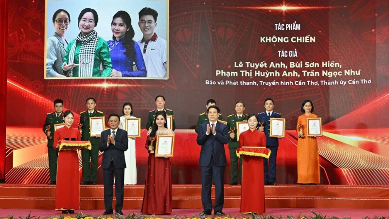 Президент Лыонг Кыонг и Постоянный член Секретариата ЦК КПВ Чан Кам Ту вручают премии категории A авторам лучших работ.