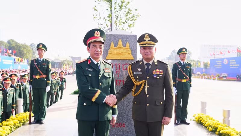 Генерал армии Фан Ван Жанг, министр национальной обороны Вьетнама, и генерал армии Тиа Сеиа, заместитель премьер-министра, министр национальной обороны Королевства Камбоджа, делают памятный снимок у пограничного столба №171 в международном пункте пропуска Бавет (Камбоджа). (Фото: ВИА)