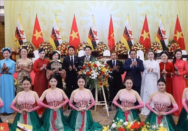 Президент Лыонг Кыонг, Премьер-министр Фам Минь Тьинь вместе с Султаном Брунея-Даруссалама Хаджи Хассаналом Болкиахом и принцем Брунея Абдулом Матином позируют с вьетнамскими артистами. (Фото: ВИА)