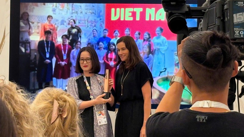 Директор выставочного дома Вьетнама До Лан Фыонг получает бронзовую награду в номинации «Лучший коллектив павильона». (Фото: предоставлено Департаментом международного сотрудничества)
