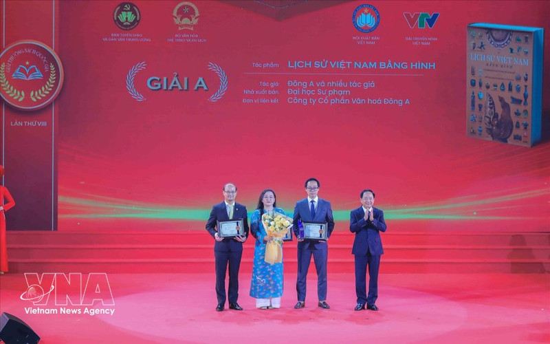 Заведующий Отделом ЦК КПВ по пропаганде, политическому воспитанию и работе с народными массами Чинь Ван Кует вручает премию А авторам и авторским коллективам — лауреатам премии. (Фото: ВИА)