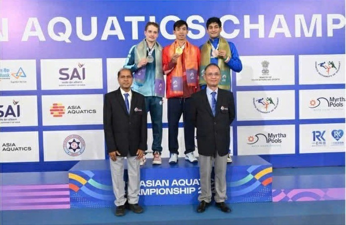 Хюи Хоанг стоит по центру на пьедестале, получая золотую медаль чемпионата Азии.