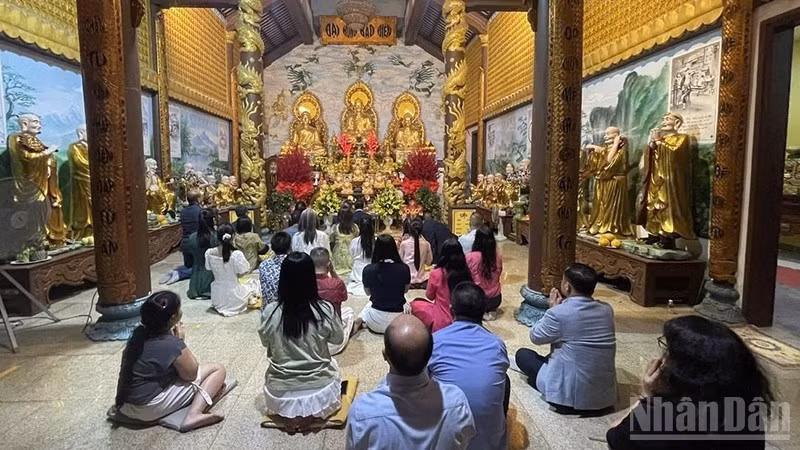 Представители вьетнамской общины в Лаосе с благоговением возносят молитвы о мирном и счастливом новом годе. (Фото: Зюи Тоан)