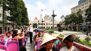 Иностранные туристы посещают центральную часть города Хошимин на двухэтажном автобусе. (Фото: ВИА)