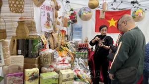 Посетители осматривают и знакомятся с продукцией на стенде Торгового представительства Вьетнама в Гонконге. (Фото: ВИА)