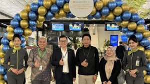 Представитель Vietnam Airlines в Индонезии (третий слева) вместе с первыми пассажирами в международном аэропорту Сукарно–Хатта, Индонезия. (Фото: ВИА)