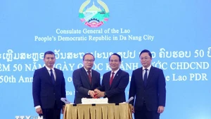 Генеральный консул Лаоса в Дананге Супхань Хадаохеуанг, Постоянный заместитель секретаря Парткома г. Дананга Нгуен Динь Винь и делегаты разрезают праздничный торт. (Фото: ВИА)