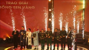 Заместитель министра культуры, спорта и туризма Та Куанг Донг и постоянный заместитель заведующего Отделом ЦК КПВ по пропаганде, политическому воспитанию и работе с народными массами Лай Суан Мон вручают премию «Золотой лотос». (Фото: ВИА)