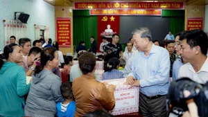 Генеральный секретарь ЦК КПВ То Лам вручает жителям подарки. (Фото: Тху Хюэ)