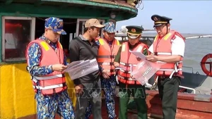 Офицеры и солдаты Командования пограничной охраны провинции Ниньбинь совместно с провинциальным поддепартаментом рыболовства и Департаментом сельского хозяйства и развития сельских районов проводят разъяснительную работу среди рыбаков, находящихся в море, по вопросам соблюдения правил противодействия ННН-рыболовству. (Фото: ВИА)
