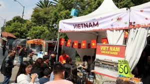 Жители района Истапалапа выстраиваются в очередь у зоны презентации традиционной вьетнамской кухни на мероприятии. (Фото: ВИА)