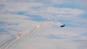 Истребители Су-30МК2 сбрасывают тепловые ловушки в небе столицы.