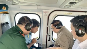 Премьер-министр Фам Минь Тьинь (второй справа) проводит воздушный осмотр скоростной автомагистрали Ка Мау — Датмуй, дороги, ведущей к острову Хонкхой, и порта двойного назначения Хонкхой с вертолёта. (Фото: ВИА)