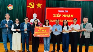 Члены рабочей делегации вручают подарки в помощь нуждающимся семьям в провинции Хатинь.