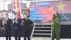 Заместитель Премьер-министра Хо Куок Зунг передаёт символический чек Вице-президенту Республики Куба Сальвадору Вальдесу Месе — сумму второго транша программы пожертвований в поддержку народа Кубы «65 лет солидарности Вьетнама и Кубы», организованной Обществом Красного Креста Вьетнама. (Фото: ВИА)