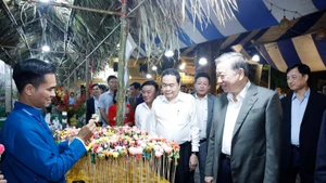 Генеральный секретарь ЦК КПВ То Лам, Председатель Национального собрания Чан Тхань Манн, Постоянный член Секретариата ЦК КПВ Чан Кам Ту и делегаты посещают павильоны OCOP. (Фото: ВИА)