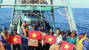 Рыбакам вручают национальные флаги и спасательные жилеты. (Фото: ВИA)