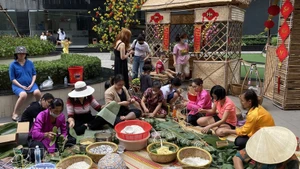 Жители жилого комплекса «Анфу» (город Тхудык) вместе заворачивают баньчынг, готовясь к празднованию Тэта. (Фото: ВИА)