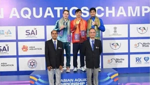 Хюи Хоанг стоит по центру на пьедестале, получая золотую медаль чемпионата Азии.