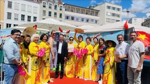 Господин Фам Хюи Фыонг (в черном пиджаке), руководитель отдела по работе с вьетнамской общиной Посольства Вьетнама в Германии, и госпожа Ева Вебер (слева от него), мэр города Аугсбург, фотографируются с представителями вьетнамской общины в Аугсбурге. Фото: ВИА