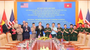 Генерал-полковник Хоанг Суан Тьен, заместитель министра национальной обороны, Посол США во Вьетнаме Марк Кнаппер и делегаты после подписания. (Фото: ВИА)