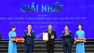 Премьер-министр Фам Минь Тьинь и товарищ Нгуен Чонг Нгиа вручают первый приз представителю авторского коллектива газеты «Нянзан». (Фото: Тхэ Дай)