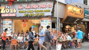 Иностранные туристы дегустируют блюда местной кухни на улице Та-хьен в Ханое. (Фото: ВИА)