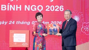 Генеральный директор ВИА Ву Вьет Чанг вручила Генеральному секретарю То Ламу фотоальбом, подготовленный журналистами Фоторедакции. (Фото: ВИА)