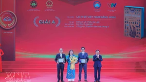 Заведующий Отделом ЦК КПВ по пропаганде, политическому воспитанию и работе с народными массами Чинь Ван Кует вручает премию А авторам и авторским коллективам — лауреатам премии. (Фото: ВИА)